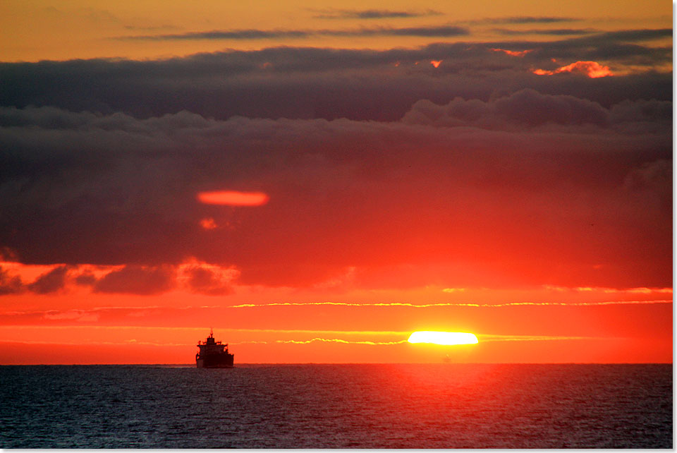 Einsamer Frachter vor Sonnenuntergang.